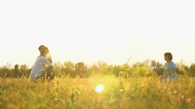 people in the park, Father catches running child, happy family, mother father in park at sunset, kid child weekend relaxation, child kid with parents playing on a walk, family outdoors, father catches