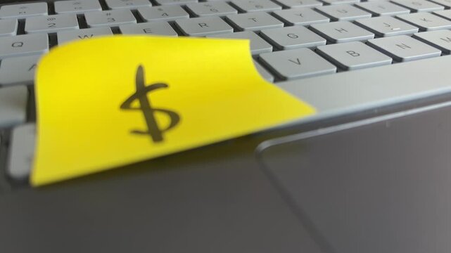 Dollar sign sticky note on laptop digital money and business