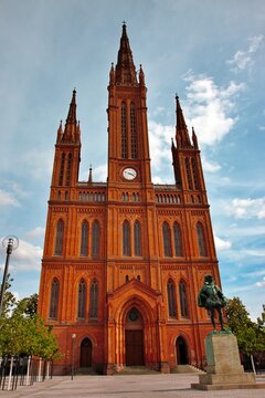 Wiesbaden, Hesse, Germany: Marktkirche with neo-Gothic brick facade and William of Orange monument under blue sky.
