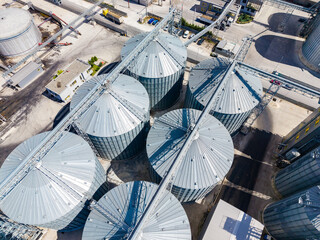 Storage silos and equipment at a grain processing site in bright daylight © DSMT