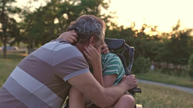 Grandfather embracing disabled child with cerebral palsy