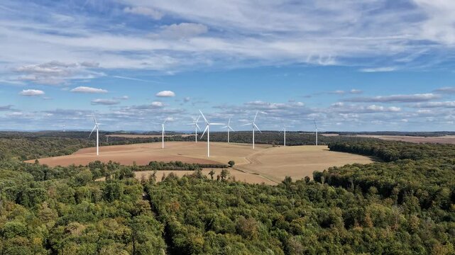 vue a&eacute;rienne du parc &eacute;olien d'Ottange en Moselle. effet hyper lapse sur les nuages qui avancent  et les pales d'&eacute;oliennes qui tournent tr&egrave;s vite. Ciel bleu nuageux en septembre 2026 France
