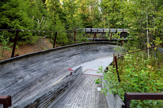 Wooden bobsleigh chute in summer in the forest on a clear sunny day. Sights of Russia, World tourism.