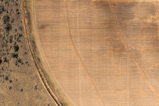 Aerial view of a dry and unproductive centre pivot irrigation field showing signs of severe drought and crop failure in iNtabazwe, Free State, South Africa.