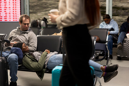 Tired couple sleeping during flight delay in airport lounge