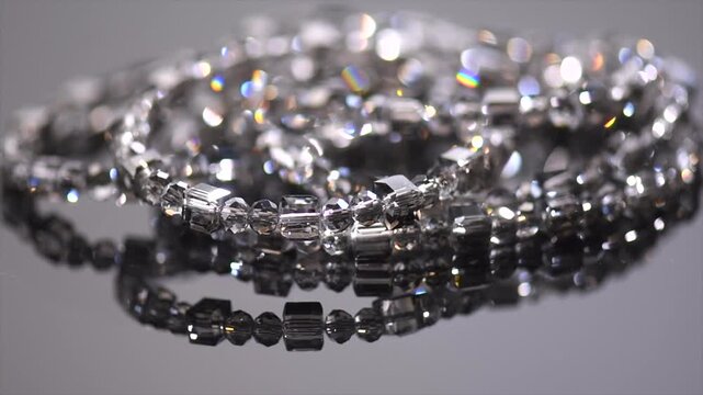 Crystals bracelet or necklace, gems, diamonds over black background, beautiful gems, rhinestones, brilliants sparkling with colorful caustics, rainbow lights. Moissanite. Zirconia rotating