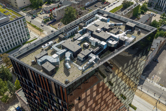 Aerial view of modern self-sufficient office building with rooftop HVAC systems and green roof elements in Poland.
