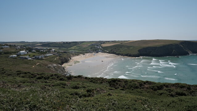 Sandy beach and coastal village viewed from cliffside path