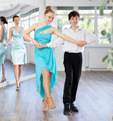 Fototapeta premium Pair dances - girl and boy in festive attire dance waltz