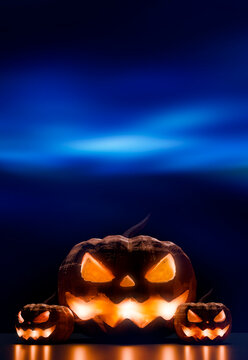 Halloween jack o lantern pumpkins glowing under blue night sky 3d render