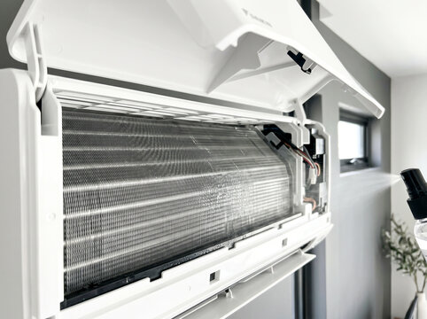 Open wall mounted air conditioner split system showing internal coil fins for service
