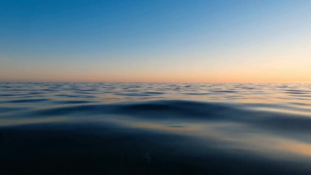 Calm ocean waves at sunset, gentle sea surface background, serene golden hour horizon, peaceful marine atmosphere