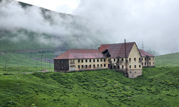 Abandoned house in the mountains with clouds