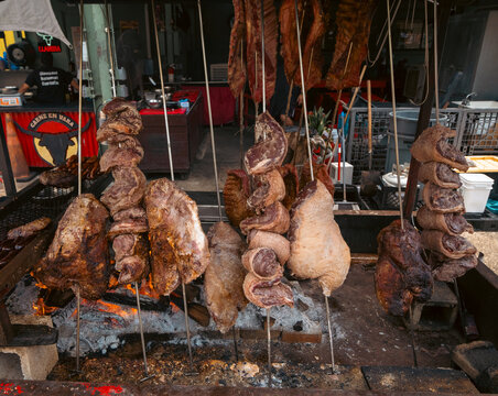 Hollywood, FL, USA - August 30, 2026: Traditional Carne en Vara meat skewers roasted over a charcoal fire at Yellow Green Farmers Market.