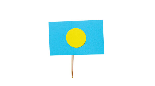 Isolated small paper flag of Palau on a toothpick, a symbolic representation of the nation.