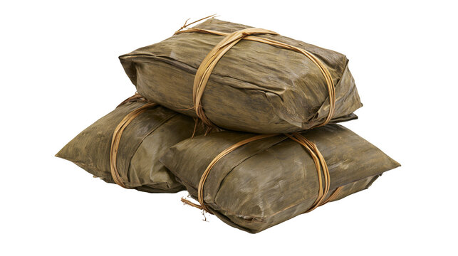 Isolated delicious traditional steamed food packages wrapped in banana leaves tied with natural twine