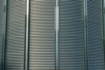 corrugated steel grain silo with ribbed metal walls and vertical supports, industrial storage bin, agricultural infrastructure, industrial architecture, metal texture and structural detail, close view © rikstock