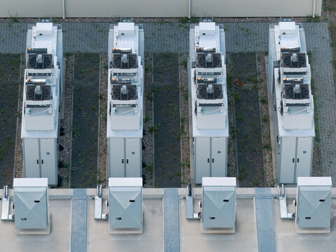 Aerial view of BESS battery energy storage system with rows of industrial power units and cooling fans in Uckermark, Brandenburg, Germany.
