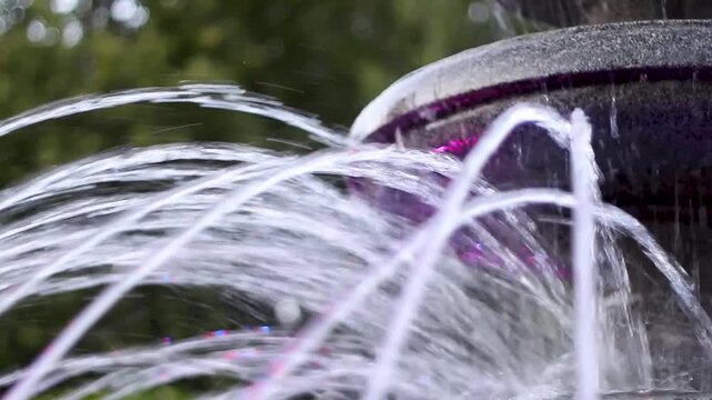 Water jets spraying from a stone fountain in a garden