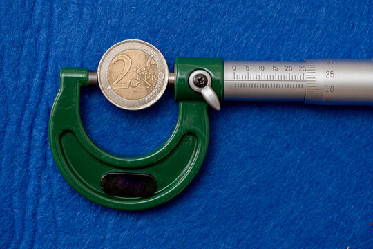Measurement of the diameter of euro coins using a high-precision instrument, a micrometer.