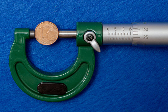 Measurement of the diameter of euro coins using a high-precision instrument, a micrometer.