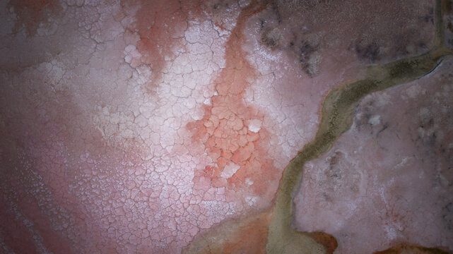 Aerial view of the vibrant pink salt crust and cracked patterns of Hutt Lagoon Pink Lake in Yallabatharra, Western Australia, Australia.