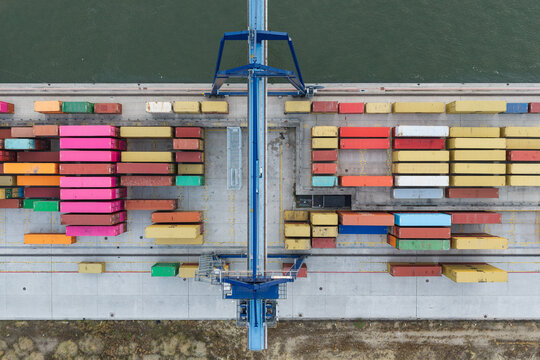 Aerial view of Haven Genk container terminal featuring rows of colorful shipping containers and industrial cranes for cargo handling in Genk, Vlaanderen, Belgium.
