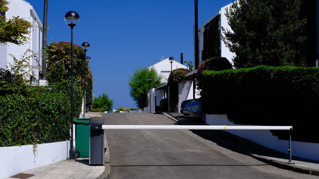 Gated Residential Driveway with Modern White Houses