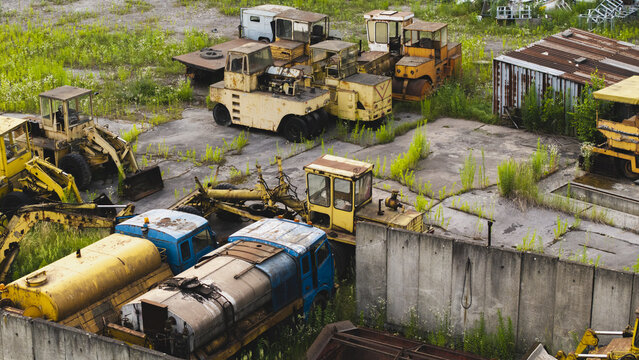 Aerial view of abandoned industrial machinery and heavy construction equipment at a derelict industrial site