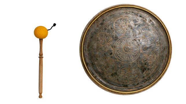 Isolated traditional musical instruments, brass gong with ornate pattern and wooden mallet