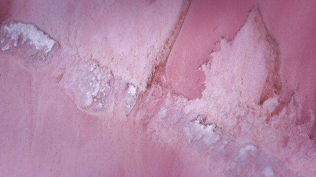Aerial view of Hutt Lagoon Pink Lake showing vibrant pink water and white salt crust formations in Yallabatharra, Western Australia, Australia.