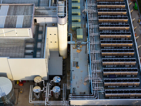 Aerial view of a data center rooftop featuring rows of industrial HVAC cooling units, complex mechanical pipework, and heat rejection equipment in Sydney, New South Wales, Australia.