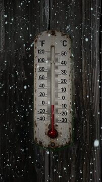 Old outdoor thermometer in the winter vertical