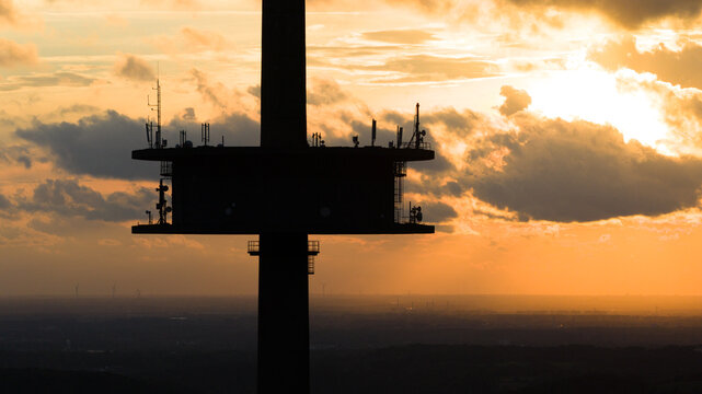 Aerial view of the silhouette of Fernmeldeturm Witzhelden against a vibrant sunset sky with clouds in Leichlingen, Nordrhein-Westfalen, Germany.