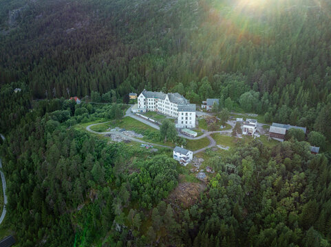 Aerial view of Harastolen, the historic Luster sanatorium, surrounded by dense pine forests and rugged mountain terrain in Luster, Vestland, Norway.