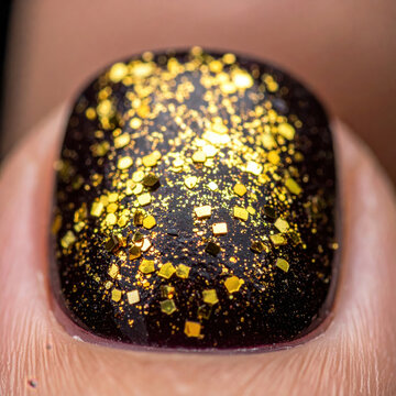 Black glitter fingernail, gold decoration, close up manicure, glossy surface, metallic sparkle