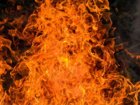 Dynamic close-up of blazing orange and yellow fire flames creating a textured fiery background. 