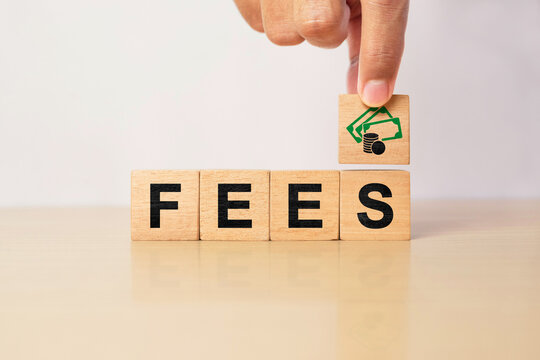 Wooden blocks spelling fees with money icon on top. Concept of service charges, transaction costs, banking fees, administrative expenses, financial obligations and business cost management.