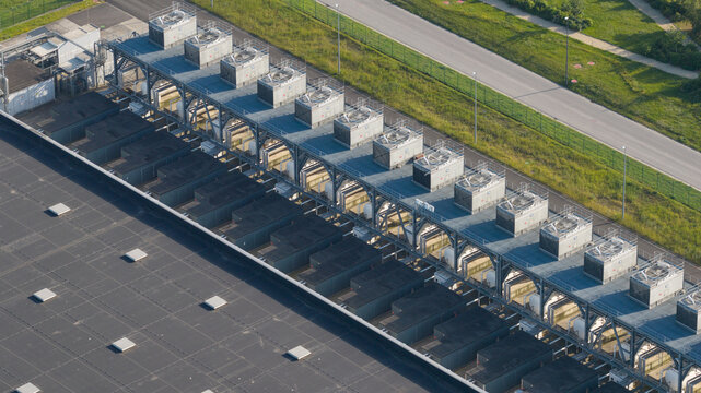 Aerial view of data center complex featuring large industrial buildings, cooling systems, and solar panels in Saint-Ghislain, Region wallonne, Belgium.