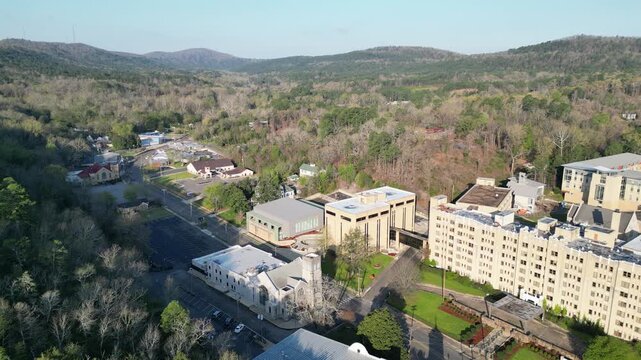 Aerial view of town buildings and forested hills.
