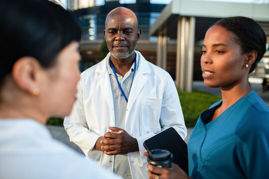 Doctors and nurse discussing patient care outside hospital