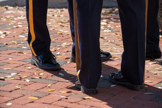 Dark blue uniform trousers with yellow stripes, lampasse, worn down the side of the pants. The military or police are wearing shiny black dress shoes. The army service pants are pressed and tailored.