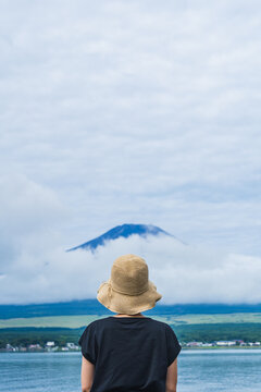 後ろ姿の女性と富士山｜山中湖・湖畔から夏の富士山を眺める女性・日本の風景