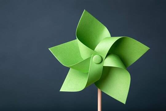 Green paper windmill toy on dark blue background