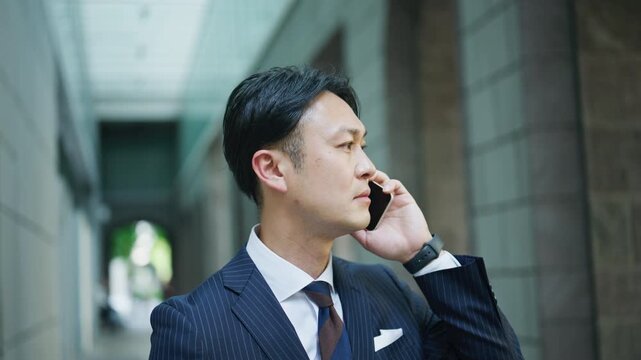 Japanese businessman taking a difficult call in a quiet colonnade