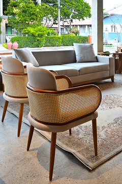 modern patio lounge with woven rattan armchairs and beige sofa, cozy outdoor living space design, hospitality interior concept