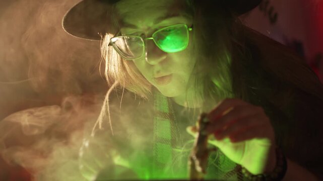 A realistic witch brewing a potion. She waves her hands over the cauldron, holding a pumpkin and a dried chicken foot, and chants a spell. Magic and a mystical atmosphere.