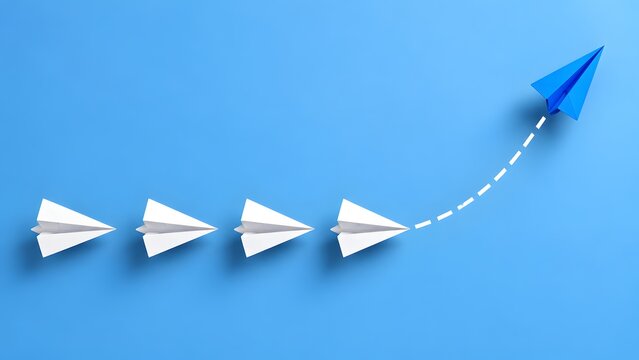 Business leadership and innovation concept showing blue paper airplane changing direction and breaking away from white airplanes