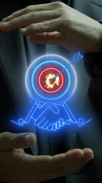 Businessman hands protecting glowing target bullseye with user avatar and handshake vertical shot. Customer acquisition goal, client partnership agreement, and business trust alliance idea concept.