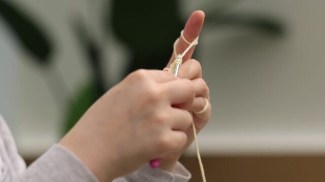 Hands knitting yarn with knitting needles